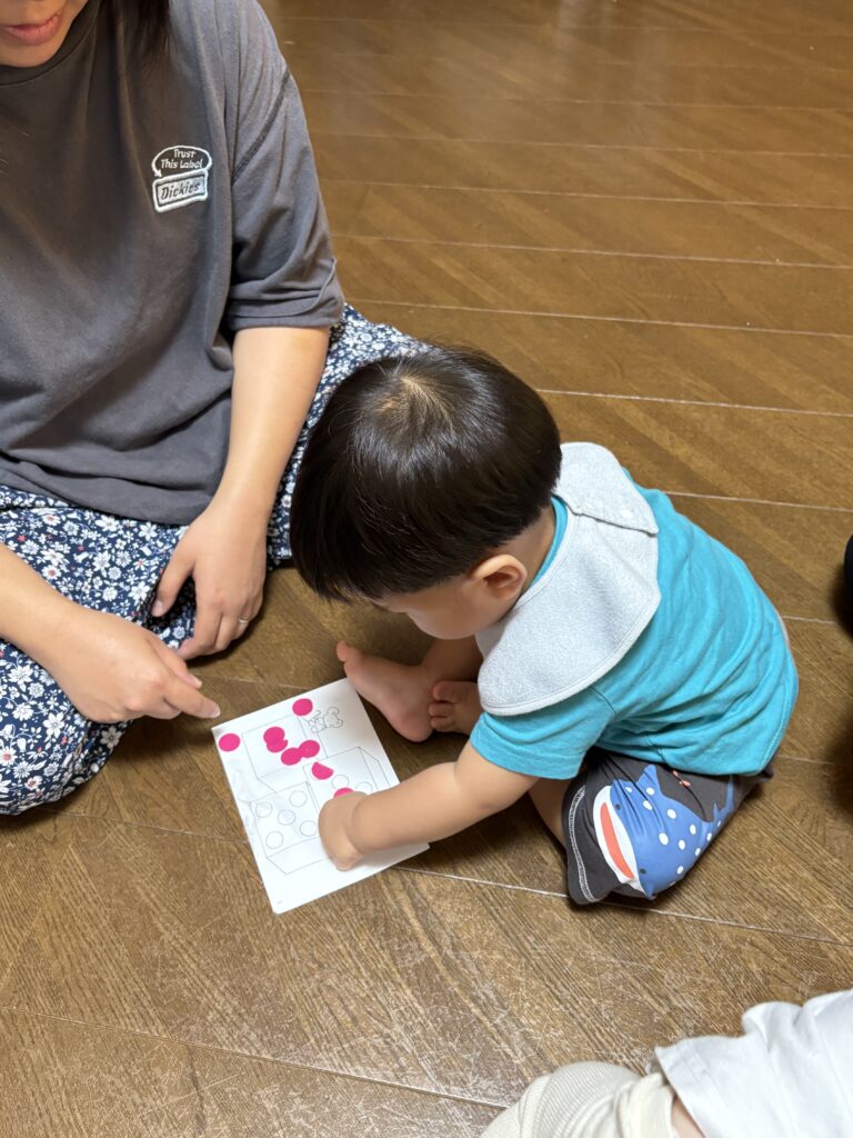 脳トレピアノ®キッズは、音楽を通して地頭を鍛えながら、非認知能力の高いお子さんを育てていくことを目的にしています。
もちろん、ピアノにもたくさん触れていただきますが、このシールハリは目と手の協応を高めたり、指の発達を促したりの力をつけていきます。
「○にピッタリ貼れなくても大丈夫ですよ！Aちゃんはここに貼ろうって一生懸命考えているんですよ。
目と指の神経回路がつながってきたらできるようになってくるんですよ」と私がお伝えすると、ママはニッコリ笑いながら見守ってくださいました。
一生懸命考えて頑張ったよね！
このように、発達のお話も交えながらのレッスンです。
お子様はもちろんママも子育ての色々な知識を学べる素敵なお教室です。
体験レッスンにいらしてみませんか？